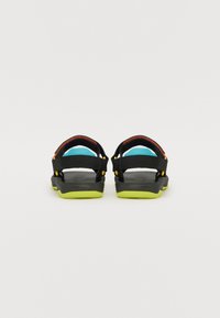 Sorte sandaler med justerbare stropper; lys blå polstring og livlige gule detaljer. Har en teksturert svart såle og lett design.