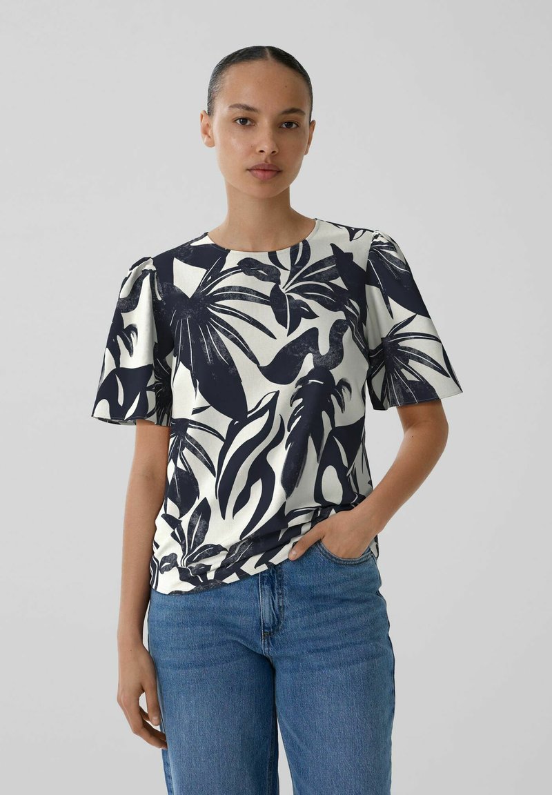 Kurzärmelige Bluse in Weiß mit dunkelblauem tropischem Blattmuster, runder Ausschnitt und leicht pufferten Ärmeln, aus leichtem Stoff gefertigt.