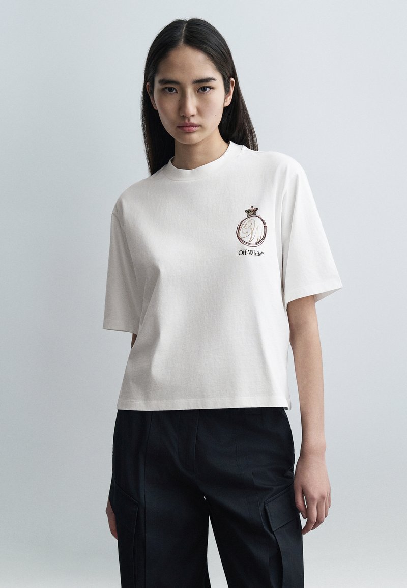 Κοντομάνικο, εκρού βαμβακερό t-shirt με κεντημένο λογότυπο με στέμμα. Εφαρμοστό, στρογγυλό ντεκολτέ με άνετο, κουτί σχήμα.