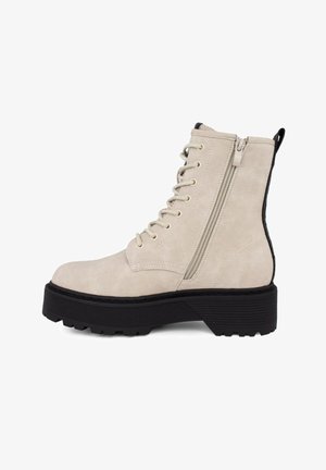 Stivaletti alla caviglia in finta suede beige con una suola platform nera spessa. Le caratteristiche includono lacci frontali e una cerniera laterale.