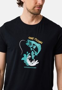 Mustapaita, jossa on kalan grafiikka, vesipisarasuunnittelu ja teksti "GONE FISHING" keltaisena ja sinisenä kuvan yläpuolella.
