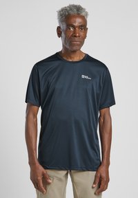 T-shirt à manches courtes bleu marine fabriqué en tissu léger et évacuant l'humidité. Doté d'un petit logo de la marque sur la zone gauche de la poitrine.