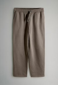 Brūni, viegli auduma sporta bikses ar elastīgu jostu, auklu, divām sānu kabatām un sašaurinātiem nogaliem. Gluda tekstūra, bez rakstiem.