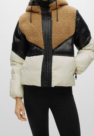 Kurtka puchowa z brązowym polarowym górnym panelem, czarnymi błyszczącymi rękawami i kremowym dolnym segmentem. Posiada kaptur oraz zamek błyskawiczny, a także dwie boczne kieszenie.