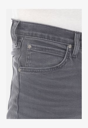 Jean de mezclilla gris con diseño de cinco bolsillos, herrajes plateados y un ajuste slim. La tela tiene una textura suave con ligeros desvanecimientos.