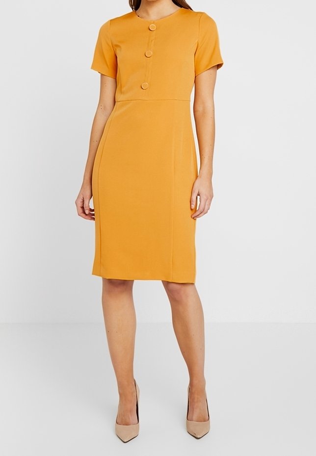 Vestido ajustado de color mostaza con mangas cortas y escote redondo, que presenta tres botones decorativos en la parte delantera. Textura de tela suave.