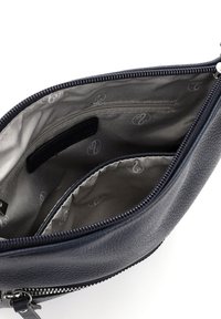 Navy textured leather pouch with a zip closure, featuring a beige lined interior, one zip pocket, and a slip pocket for organization.