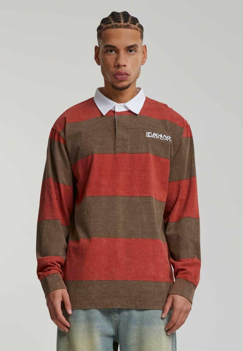 Langermet polo i brune og røde striper, med en hvit krage og logo. Myk, strukturet stoff med en avslappet passform.