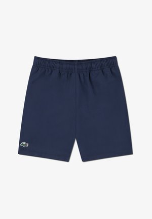 Marineblå badeshorts med elastisk midje. Har en liten brodert krokodillelogo nederst til venstre. Laget av lett stoff.