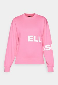 Sweat-shirt rose en coton avec manches longues, col rond, et texte blanc audacieux sur le devant et la manche. Design simple et décontracté.