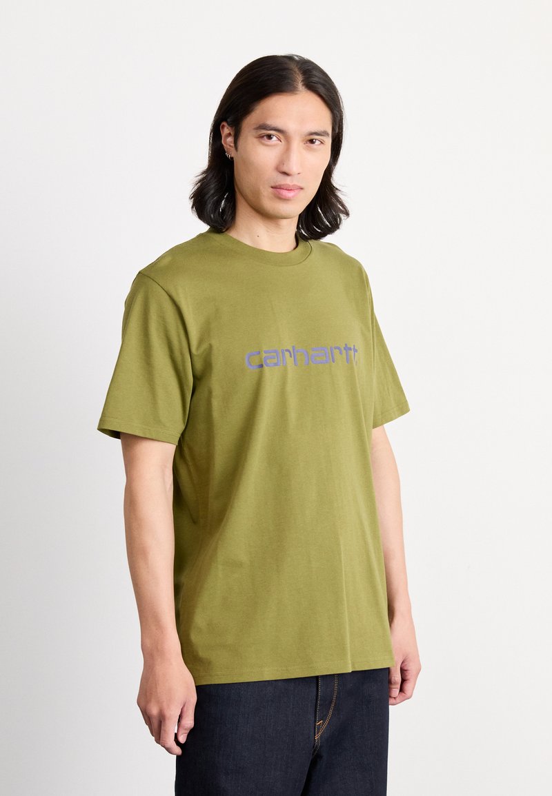 Olivgrünes Baumwoll-T-Shirt mit rundem Halsausschnitt und kurzen Ärmeln. Auf der Vorderseite ist ein blaues "Carhartt"-Logo aufgedruckt.