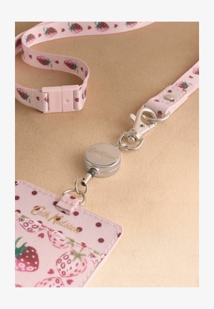 Vaaleanpunainen kaulanauha mansikkakuviolla, hopeinen vetäytyvä nimikepidike ja siihen sopiva mansikkakuviollinen korttikotelo Cath Kidstonin logolla.