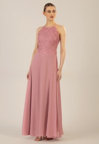 Langes pinkes Kleid mit einem figurbetonten Spitzenoberteil und einem gewellten Saum. Der fließende Chiffonrock und die dünnen Träger runden das Design ab.