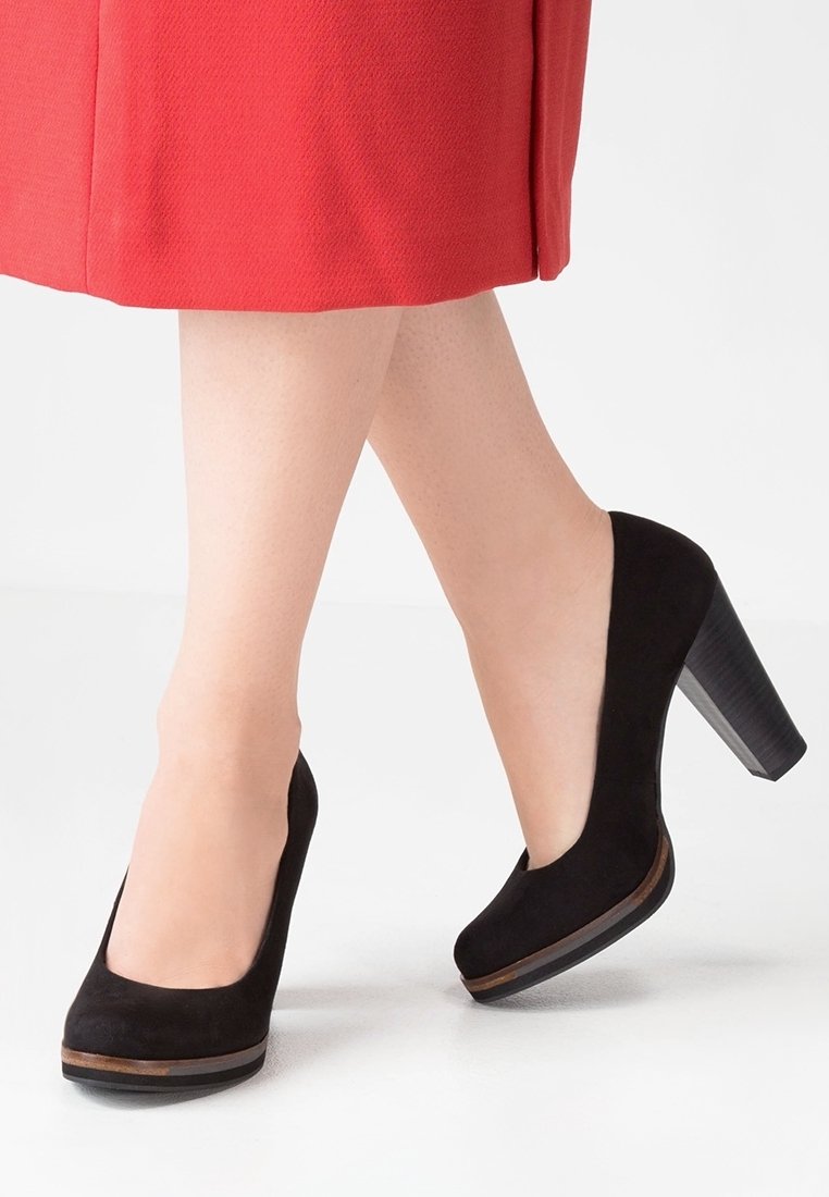 Chaussures à talons hauts en daim noir avec un bout arrondi et une plateforme texturée. Le talon est de forme bloc avec une finition imitant le bois.