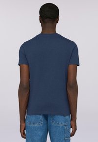 Camiseta de manga corta color azul marino con cuello redondo, hecha de algodón suave, con un corte estándar y una textura lisa, diseño liso.