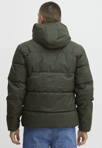 Olive green puffer jacket with a hood, featuring a quilted design and soft texture. The cuffs are elastic, and the fabric has a matte finish.