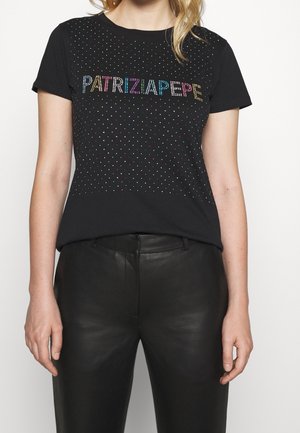 Nainen, jolla on musta lyhythihainen paita, jossa on monivärisiä strasseja, jotka muodostavat sanan "PATRIZIA PEPE" ja pieniä hajallaan olevia strasseja.
