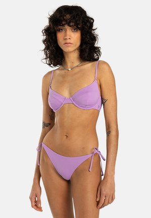 Paarse bikini set met een gestructureerde bh-top met verstelbare bandjes en een broekje met strik aan de zijkant, beide gemaakt van een soepele, elastische stof.