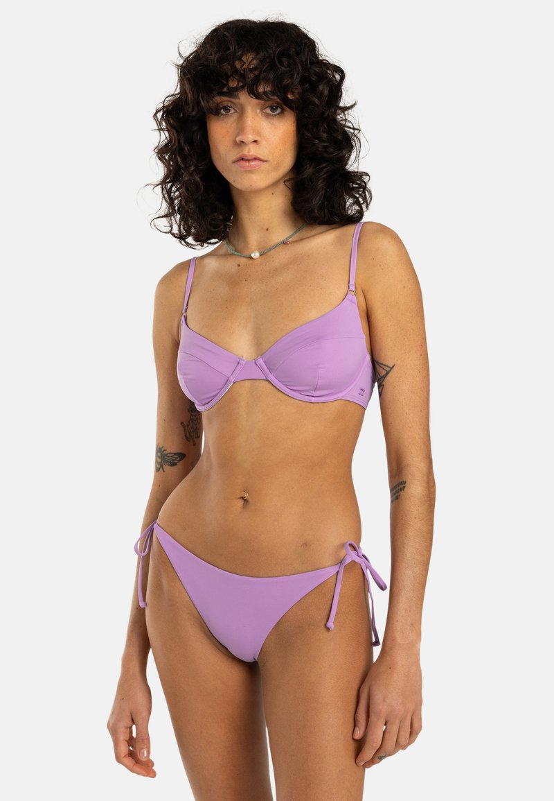 Set di bikini viola caratterizzato da un reggiseno strutturato con spalline regolabili e un pantaloncino laterale con lacci, entrambi realizzati in tessuto liscio ed elasticizzato.