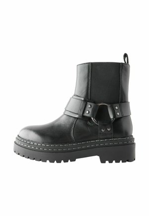 Schwarzer Lederknöchelstiefel mit dicker Sohle, elastischem Seitenpanel und dekorativem Riemen mit Metallring und Nieten.