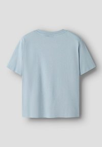 T-shirt in cotone azzurro chiaro con maniche corte, scollo rotondo e vestibilità ampia. Texture liscia, senza motivi o grafiche visibili.