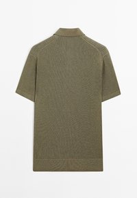 Polo shirt verde oliva a maniche corte con design a coste testurizzate, dotato di colletto classico e bordi rinforzati alle maniche e all'orlo.