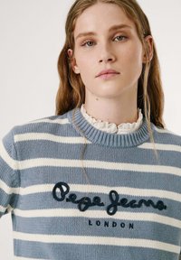 Jersey de punto a rayas azul y blanco con un cuello de canalé, que presenta el texto en relieve "Pepe Jeans LONDON" en la parte frontal.