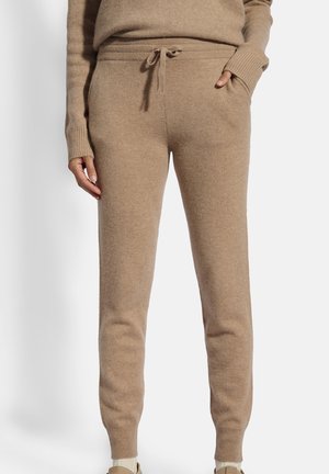 Beige gebreide joggingbroek met een trekkoord taille, ribgebreide boorden en zijzakken, vervaardigd uit zachte, gestructureerde stof.