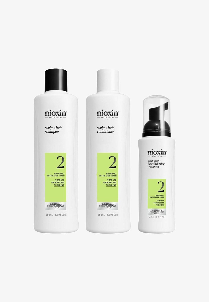 De Nioxin haarverzorgingsset bestaat uit een witte fles shampoo met een zwarte dop, een witte fles conditioner en een klein behandelingsflesje met een pomp.