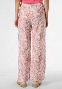 Leichte, gemusterte weit geschnittene Hosen in pink- und cremefarbener Wirbel-Design. Mit einem elastischen Bund versehen und kombiniert mit beigefarbenen Plateauschuhen.