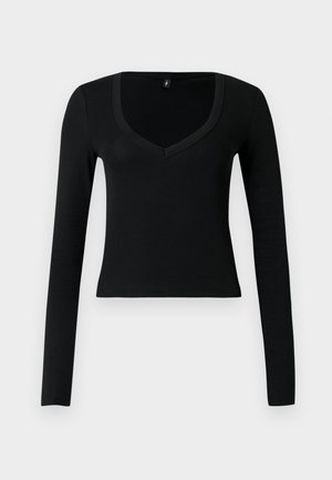 Crna uska majica s dugim rukavima s dubokim V-izrezom i blago skraćenim rubom, prikazana na svijetlosivoj pozadini.