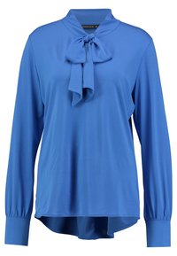 Blå långärmad blus med en slipsknut vid halsen. Tillverkad av ett slätt tyg, med en avslappnad passform och rundad nederkant.