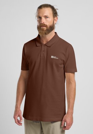 Polo marrone con colletto, maniche corte e logo sul petto a sinistra. Il tessuto appare liscio con una trama e una vestibilità uniformi.