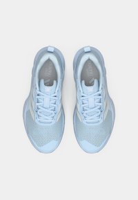 Zapatillas deportivas de color azul claro con parte superior texturizada, detalles en blanco y un collar acolchado. Presentan cordones y logotipos en la plantilla.