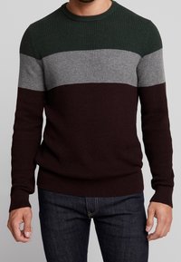 Gestrickter Pullover mit horizontalen Streifen in Dunkelgrün, Grau und Burgund. Rundhalsausschnitt, gerippte Bündchen und Saum. Waffelstruktur über das gesamte Kleidungsstück.