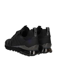 Zwarte sportieve schoenen met een gestructureerde mesh bovenkant, synthetische overlays, carbonfiber accenten en een glanzende, gewatteerde zool voor ondersteuning.