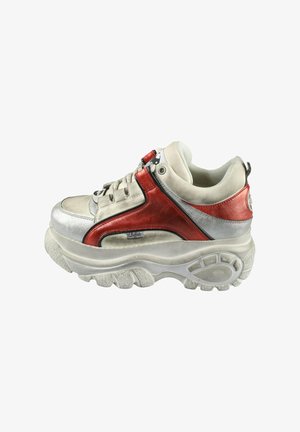 Tömbszerű sneaker, fehér velúr és fényes piros részletek keverékével, sima ezüst panellel, vastag, texturált talppal és fűzős záródással.