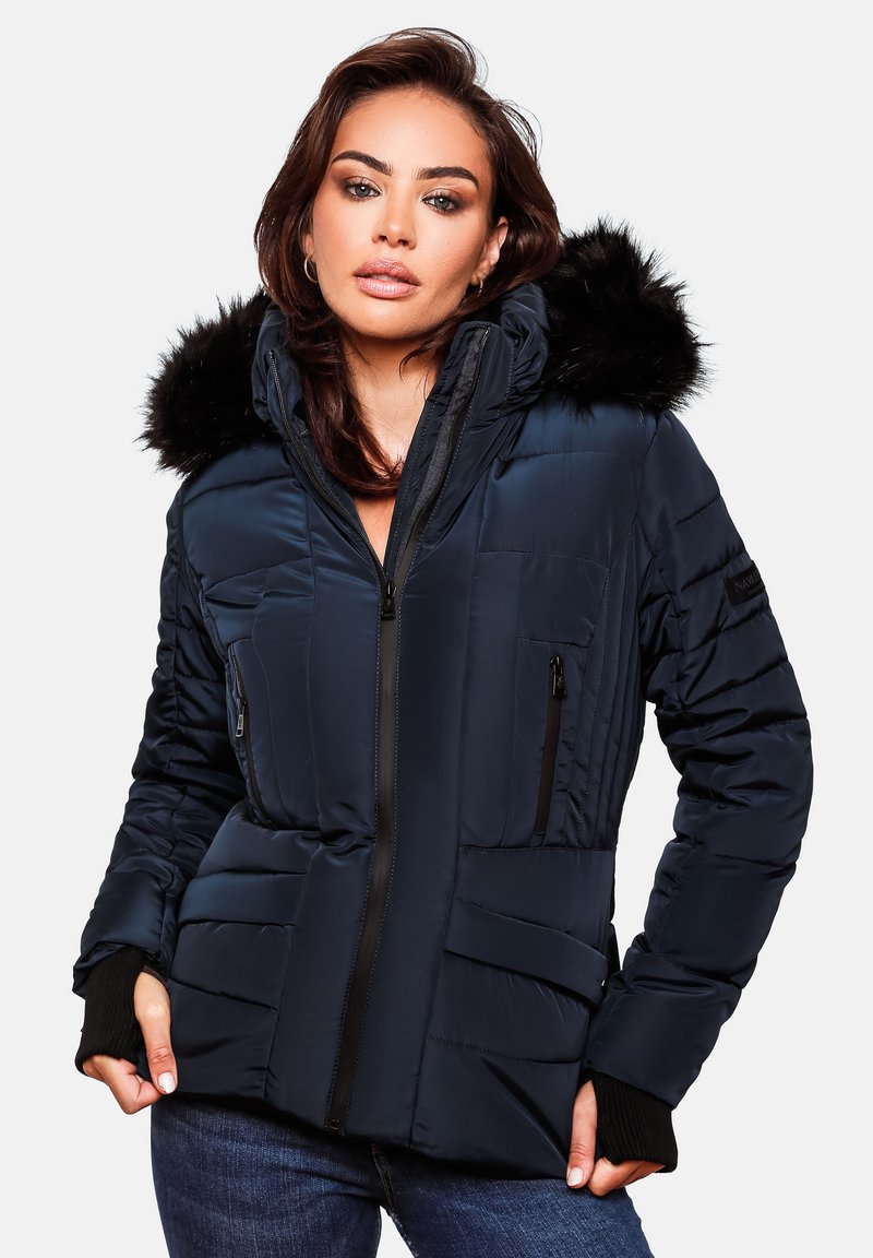 Navy puffer jacket with a detachable black fur hood, front zip closure, multiple zippered pockets, and textured panels on sleeves.