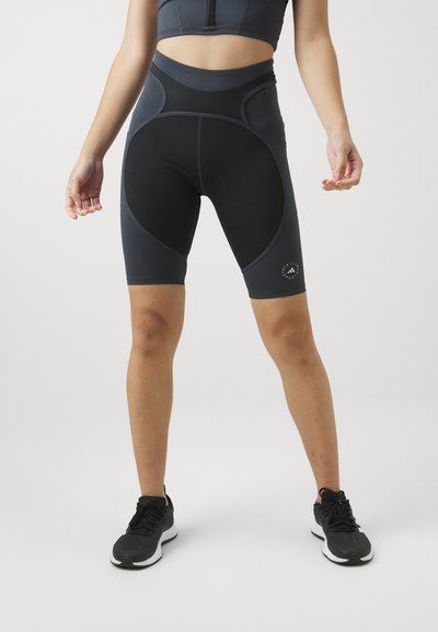 High-waisted black athletic shorts with gray accents, featuring a stretchy, smooth fabric and logo detail on the lower leg.