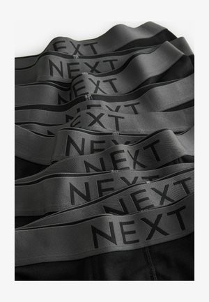 Chiloți negri cu un waistband elastic lat de culoare gri pe care este imprimat "NEXT" în negru. Mai multe perechi stivuite, evidențiind textura și designul.
