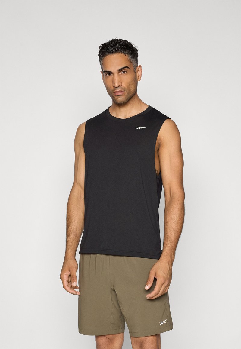 T shirt de sport noir sans manches en tissu doux, associé à un short vert olive. Comprend un petit logo sur la poitrine du t-shirt.