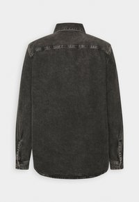 Svart denimskjorta med långa ärmar som har en klassisk krage, knäppta manschetter och en något urtvättad textur med en rundad nederkant.