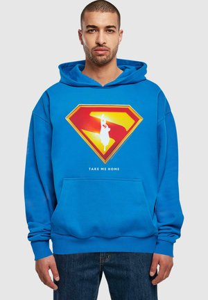 Blue hoodie featuring a large red and yellow Superman logo graphic with a white silhouette; includes a front pocket and ribbed cuffs.