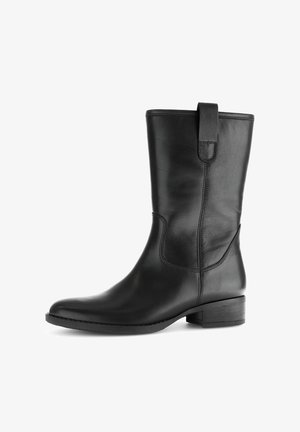 Botín negro de cuero con un acabado suave, puntera redondeada, costura lateral elevada y tacón bajo apilado. Incluye una pestaña en la parte trasera para facilitar el calzado.