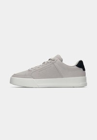 Light gray suede low-top sneaker with white sole, lace-up front, and black heel accent, shown in side profile on white background.