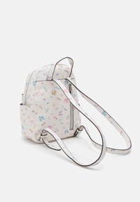 Reppu, jossa on valkoinen kuviollinen ulkopinta, jossa on värikkäitä kukkakuosia. Siinä on vetoketjullinen etutasku ja säädettävät hihnat.