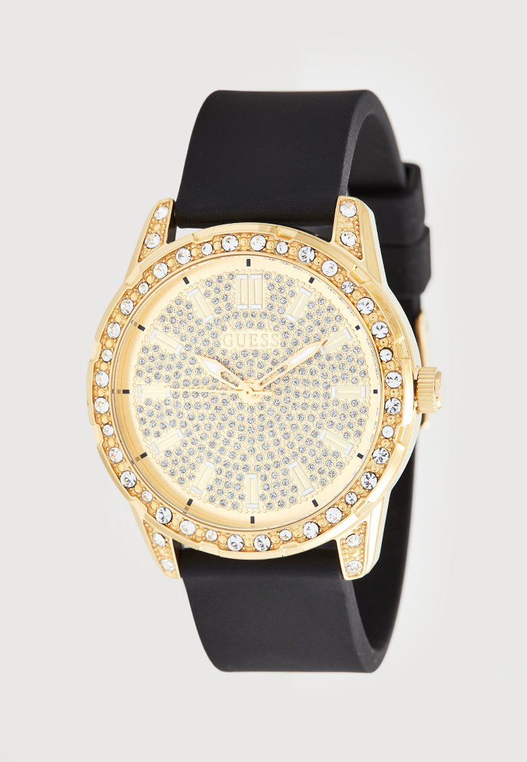 Gouden horloge met een zwarte siliconen band, kristalversieringen rond de bezel en een gestructureerde gouden wijzerplaat met zilveren uurmarkeringen.