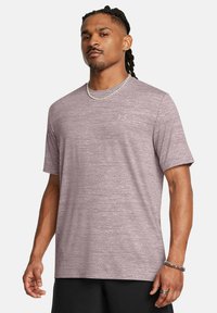 Camiseta atlética de color púrpura claro con mangas cortas, que presenta un patrón texturizado, escote redondo y un pequeño logo en el pecho.