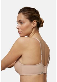 Sujetador color nude con tirantes ajustables, diseño sin costuras y cierre de gancho. Tejido suave y estilo minimalista.