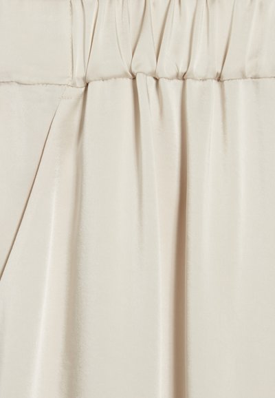 Beige satengstoff med en glatt tekstur og svak glans, med innsamlede folder øverst. Materialet faller mykt.